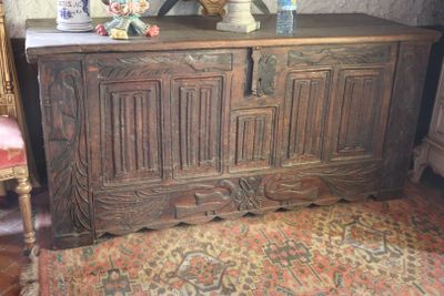a large wooden chest with a vase on top of it