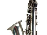 a silver saxophone that is sitting on a white surface