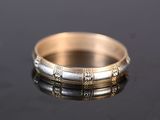 a close up of a gold and silver ring on a black surface