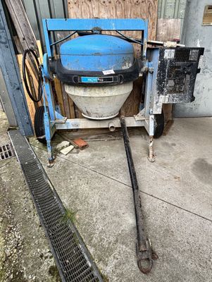 une bétonnière garée dans un garage, à côté d'une grille métallique