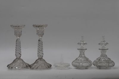 trois bougeoirs en verre transparent et un peigne posés sur une surface blanche