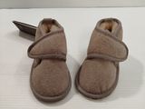 une paire de chaussures de bébé marron avec un stylo sur un fond blanc