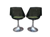 two black chairs sitting next to each other on a white surface