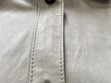 a close up of a white shirt with a black button on it
