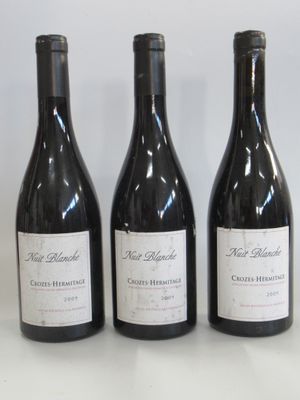three bottles of wine are lined up on a white surface