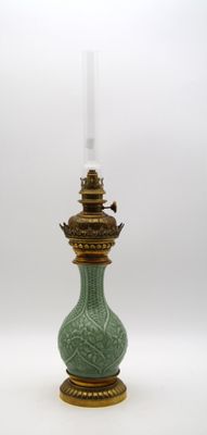 un vase vert surmonté d'un verre