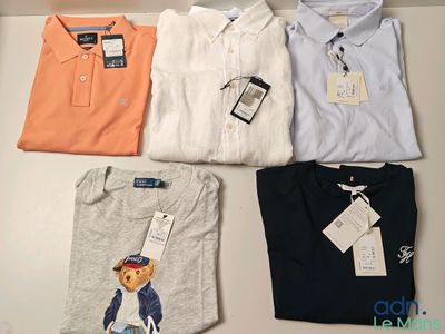 Des polos sont disposés sur une table, avec leurs étiquettes encore attachées