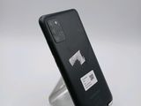 the back of a black cell phone sitting on top of a metal stand