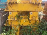 une image représentant une grande machine jaune posée au milieu d'un champ verdoyant