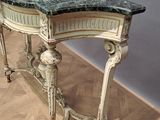 a marble top table with a marble top on a parquet floor