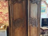 a large wooden armoire in the corner of a room