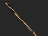 gros plan d'un bracelet en chaîne en or sur fond noir