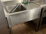 a stainless steel sink and a refrigerator in a kitchen