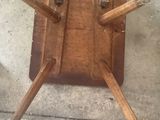 a wooden chair with four legs on a concrete floor