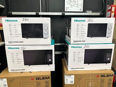 trois fours à micro-ondes empilés les uns sur les autres dans un magasin
