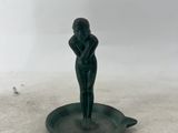 une statue représentant une femme assise sur un plat