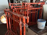 a red metal rack with a bucket of paint on it
