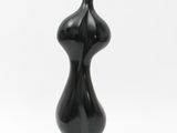 a black sculpture of a female torso on a black base