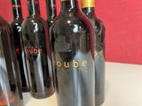 several bottles of red wine are lined up on a table