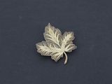 broche en feuille d'argent sur fond noir