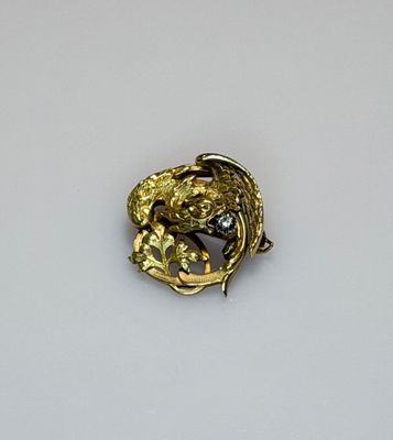 a gold brooch with a bird on it