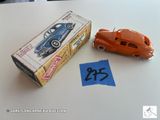 une petite voiture miniature posée à côté d'une boîte sur une table