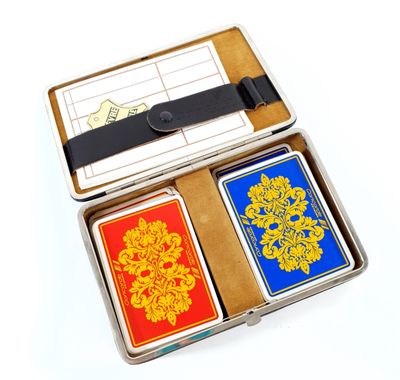 playing cards in a metal box on a white surface