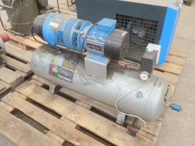 un petit compresseur d'air posé sur une palette dans un entrepôt