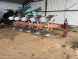 une photo représentant un tracteur et une charrue dans une grange