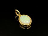a gold pendant with a white oplite stone in the center