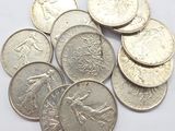 some coins are sitting on a white surface with a white background