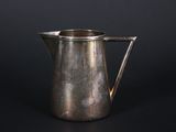 an old silver pitcher on a black background with a black background