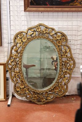 un miroir au milieu d'une pièce où sont accrochés des tableaux aux murs