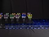 many different colored glasses lined up on a table