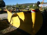 a yellow snow plow sitting on the side of the road