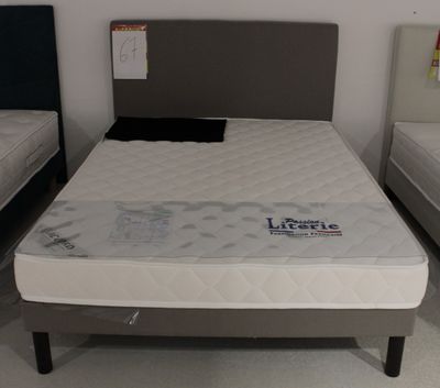 deux lits qui se trouvent dans une chambre et sur lesquels il n'y a pas de draps
