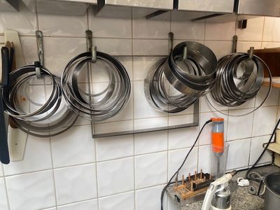 casseroles et poêles accrochées au mur d'une cuisine