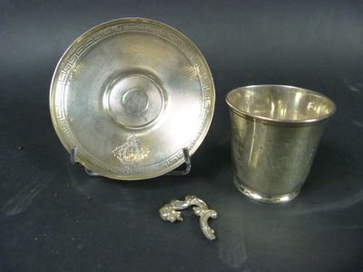 une tasse et une soucoupe anciennes en argent sur fond noir