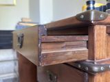 a wooden chest of drawers with metal handles in a living room