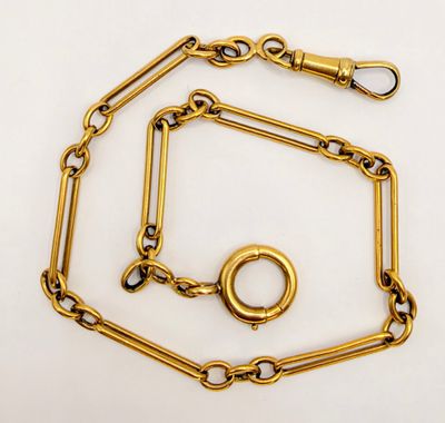 a close up of a gold chain with a ring on it