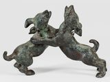 statue en bronze représentant deux chiens en train de se battre sur une surface blanche