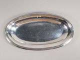 a silver tray with a silver handle on a table