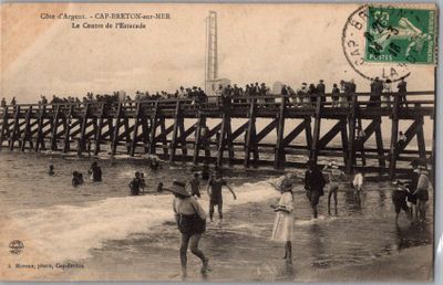 une vieille carte postale représentant des personnes debout sur un pont en bois au-dessus de l'eau