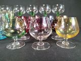 many different colored wine glasses lined up on a table
