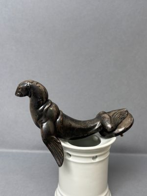 a statue of a seal sitting on top of a cup