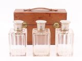 three bottles of perfume in front of a wooden box