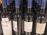 several bottles of wine are lined up on a shelf in a store