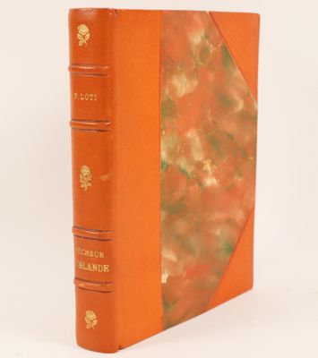 a book with an orange cover sitting on top of a white surface