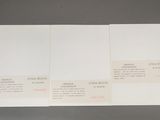 two pages of white paper with red writing on them sitting on a table