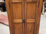 an old wooden armoire with two doors on top of it